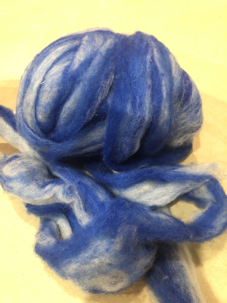 a large ball of blue and white wool before spinning