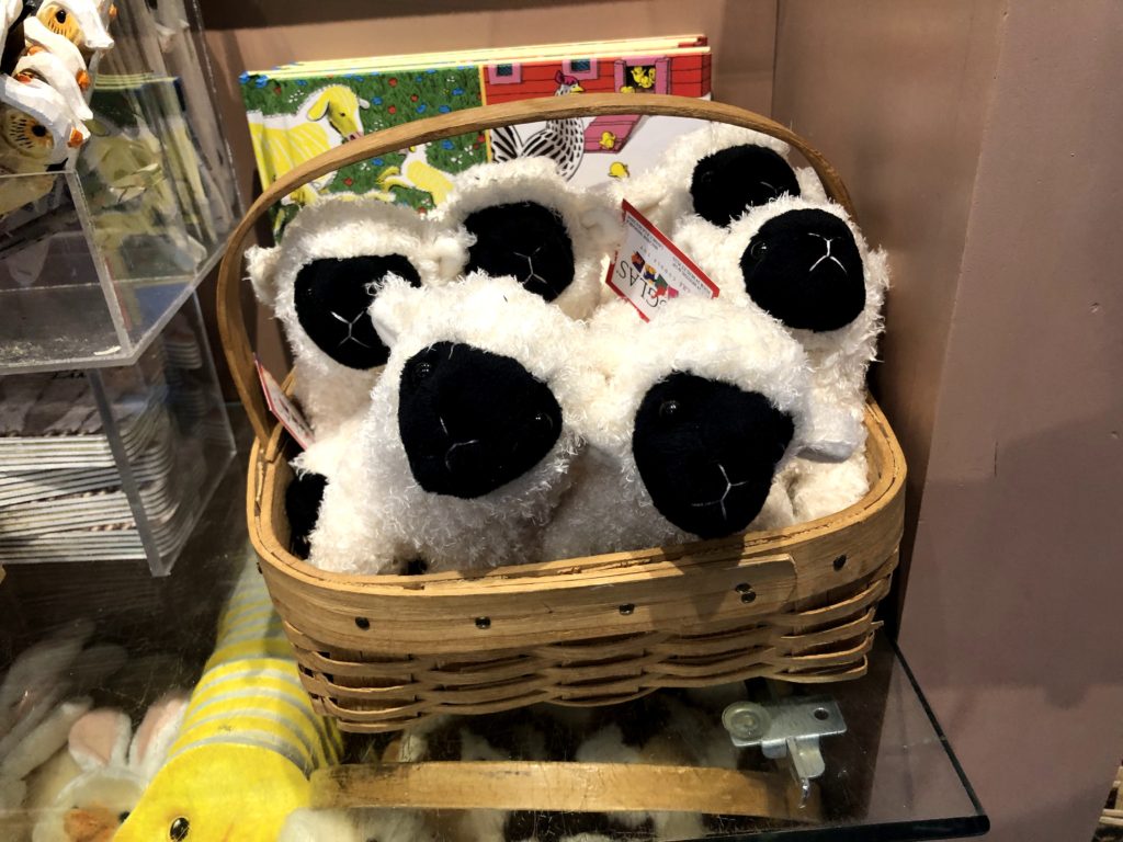 a basket of Hog Island sheep stuffies is tucked into a gift shop corner shelf
