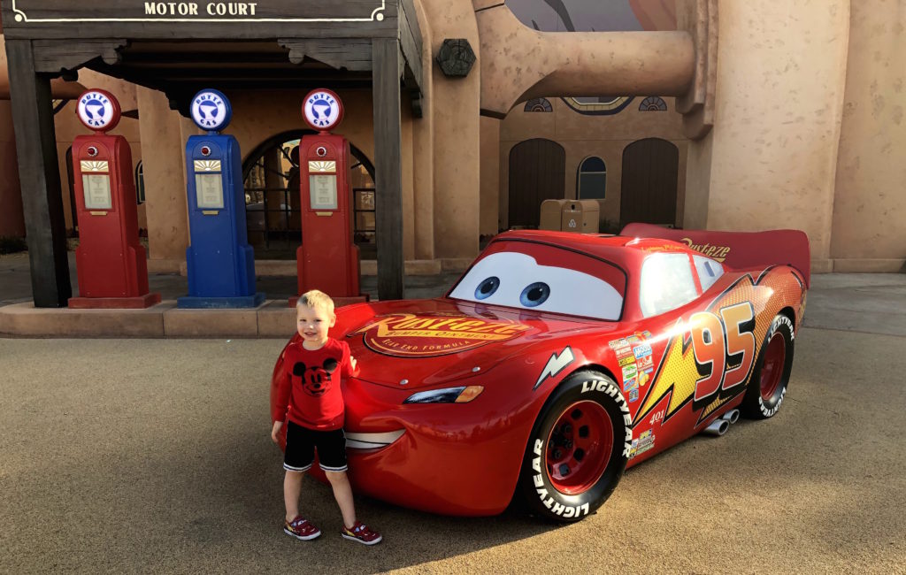 a boy poses beside a life-sized Lightning McQueen at Walt Disney World's Art of Animation Resort