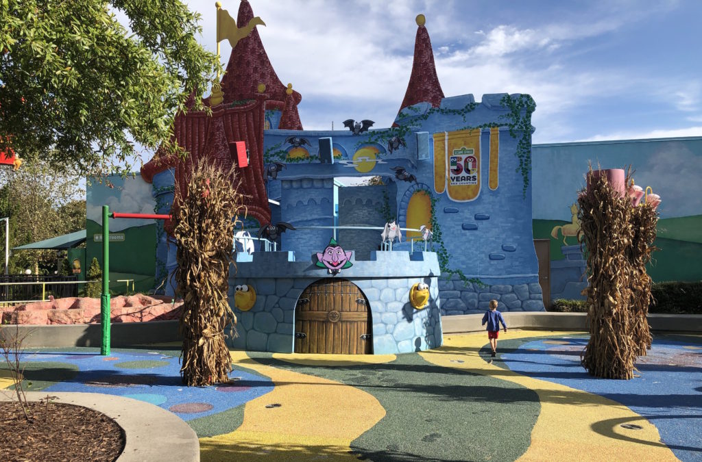 a young child walks toward a large castle façade with Sesame Street's Count on the front