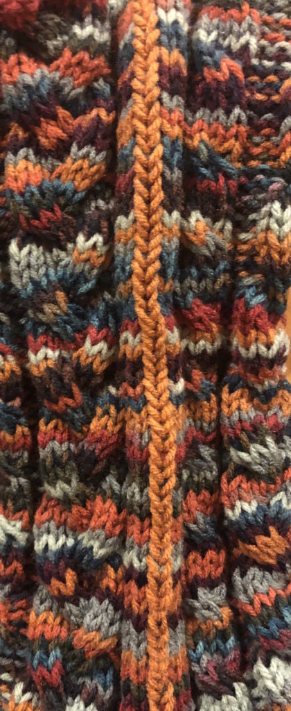a close-up of knitted cables and duplicate stitch technique
