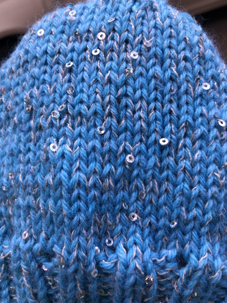 a close-up view of a knitted hat with sequins