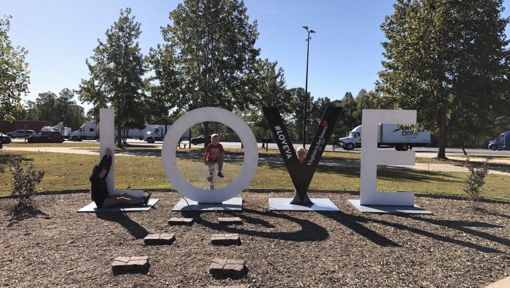 three children pose against letters of the LOVEworks at East Coast Gateway Welcome Center in New Kent, Virginia