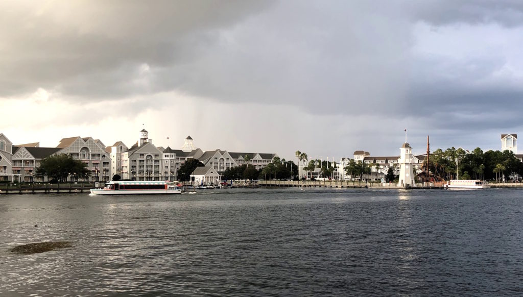 a boat crosses a lake in front of two large hotels