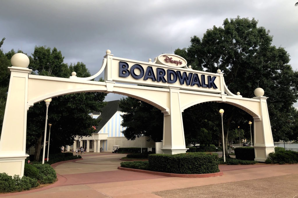 a large double entryway sign across a sidewalk reads "Disney's Boardwalk"