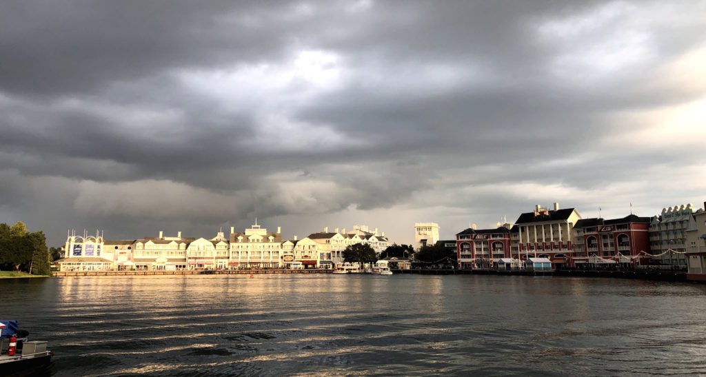 boardwalk shops and restaurants across a choppy lake as storm clouds move in