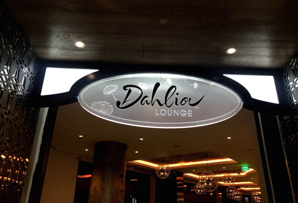 a sign with dandelions that reads "Dahlia Lounge"