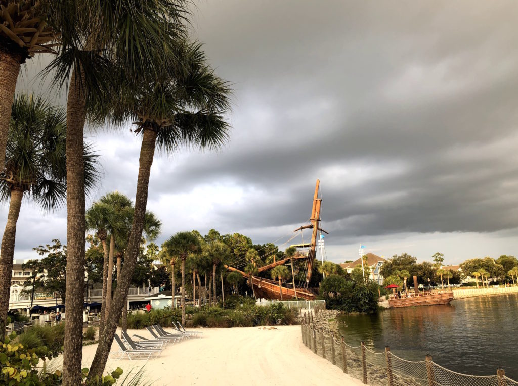 palm trees surround a lakeside beach and sunken ship slide