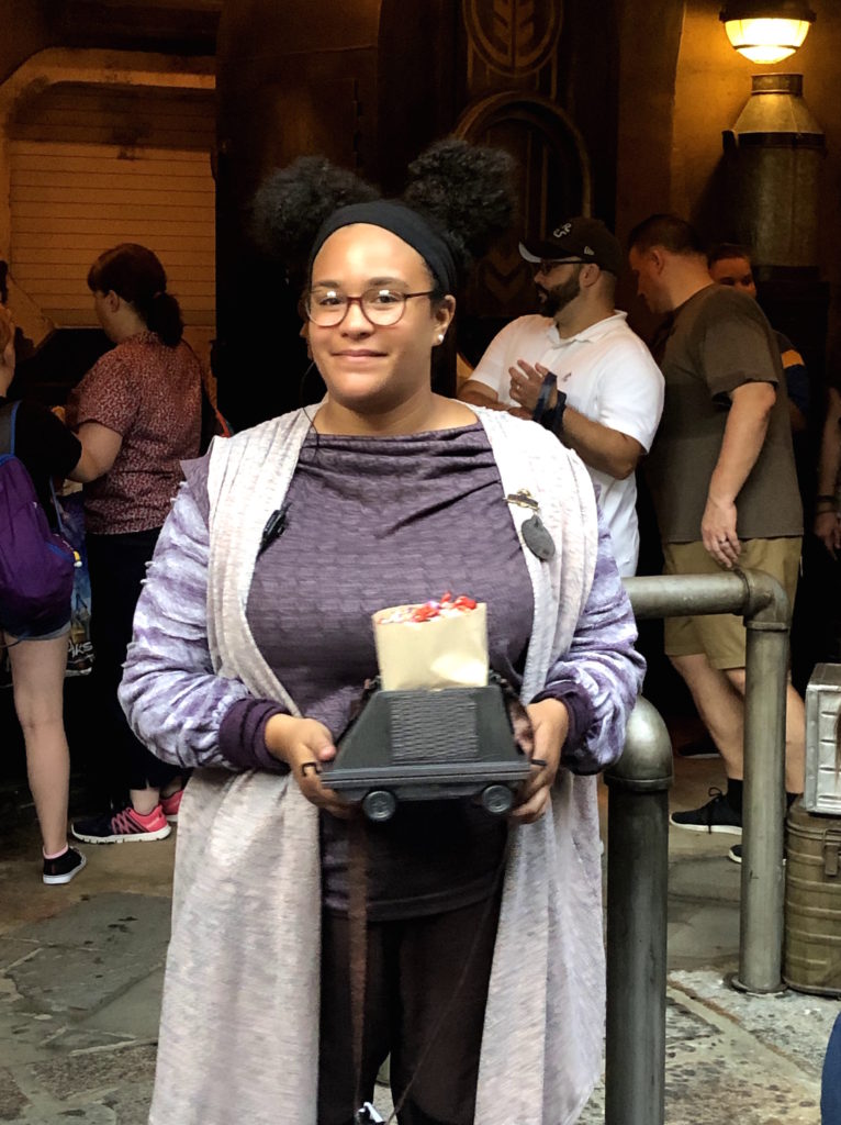 a Disney cast member holds a bag of popcorn from Kat Saka's Kettle