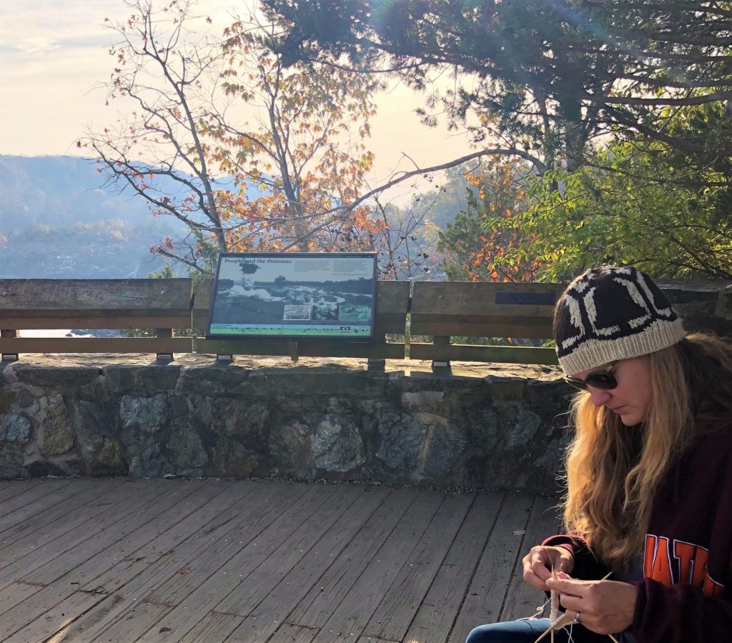 a woman knits on a Great Falls overlook