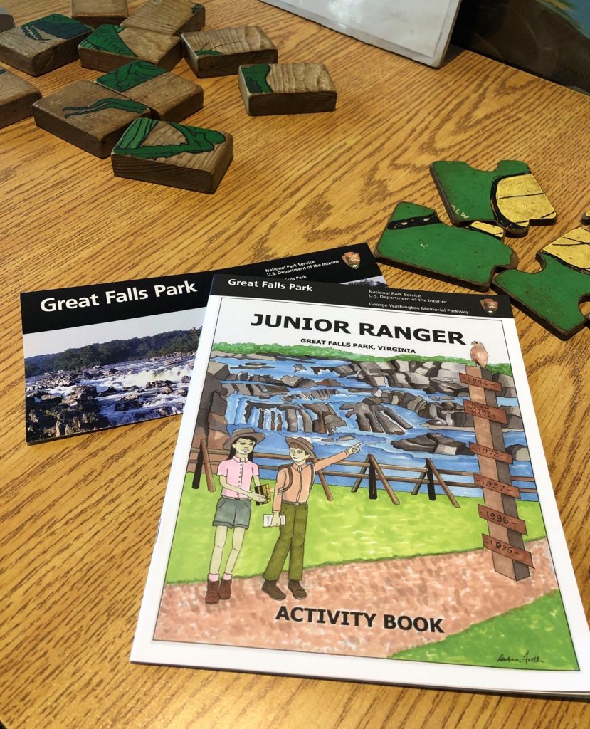 puzzle pieces and a junior ranger activity book on a wooden table