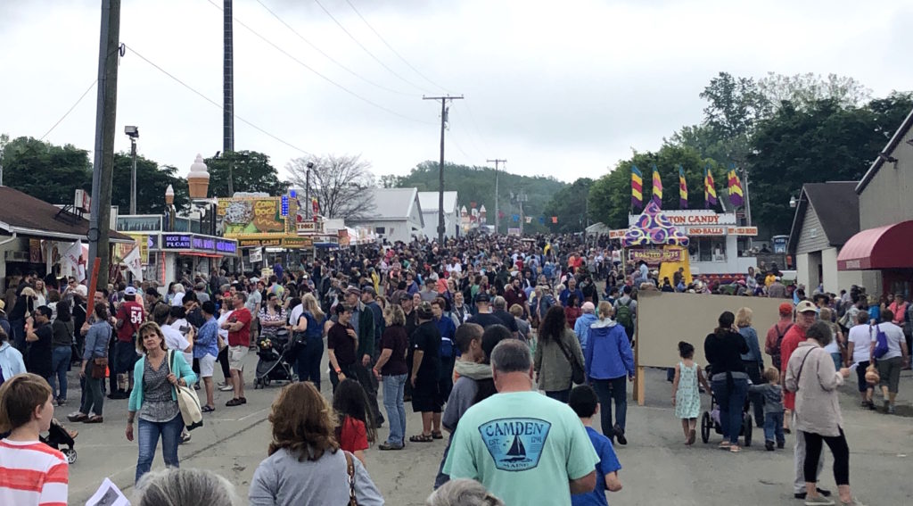 a crowd moves through the midway