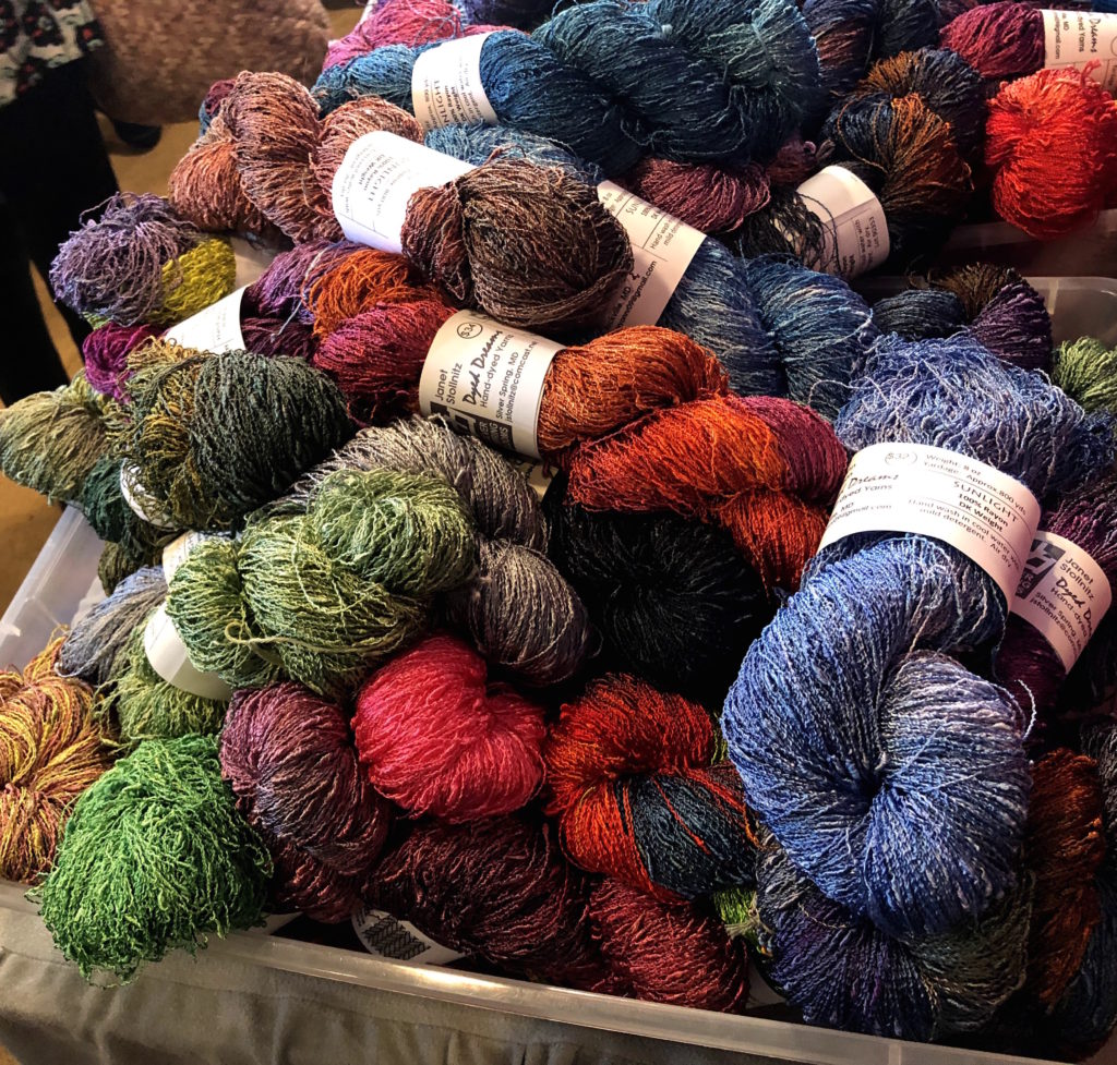 a large, colorful pile made up of skeins of rayon yarn