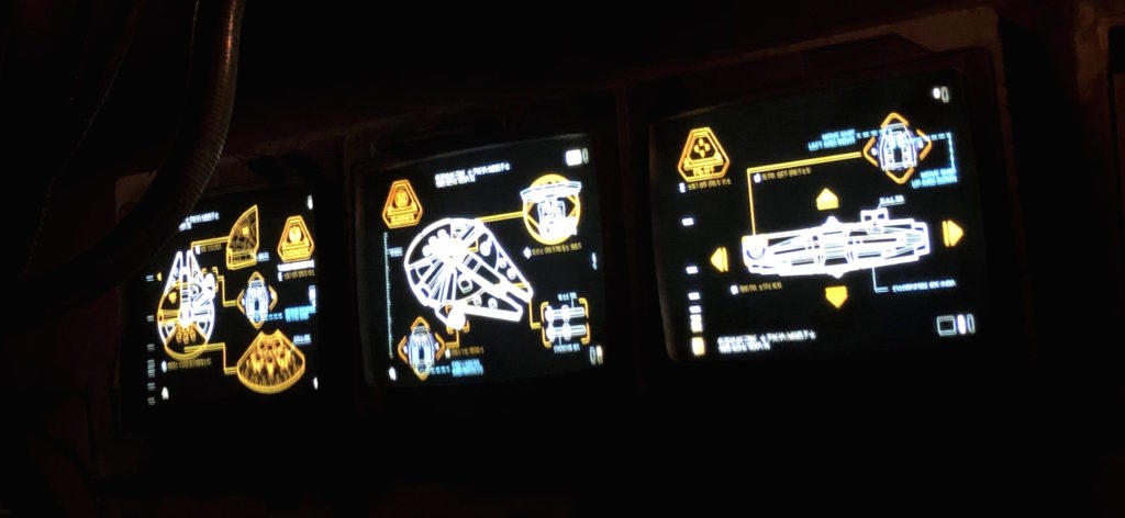 brightly lit screens display schematics of ships from Star Wars
