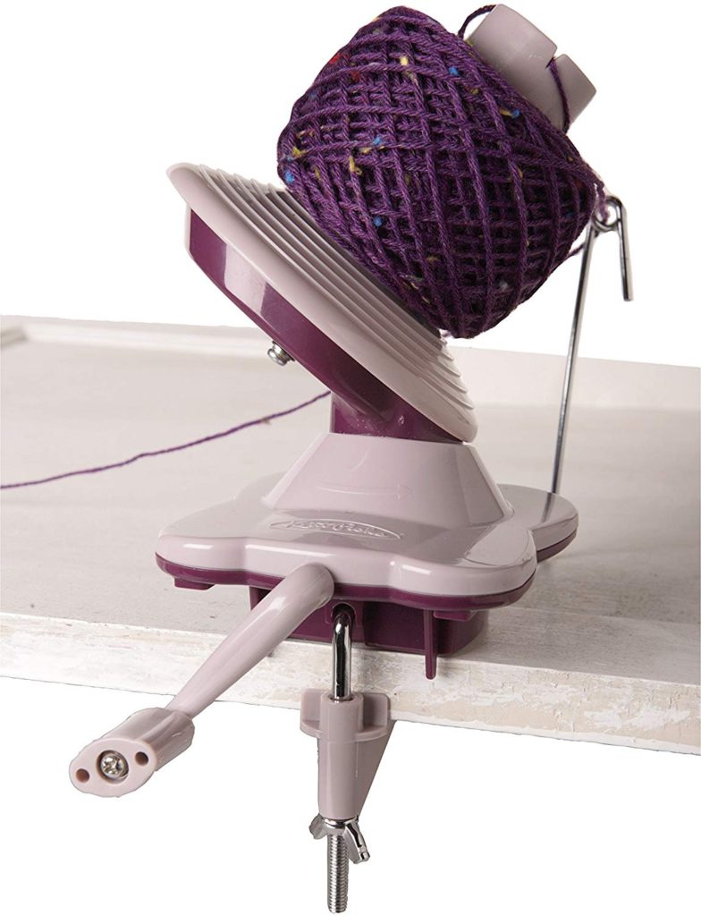 a yarn ball winder perched on the edge of a tabletop