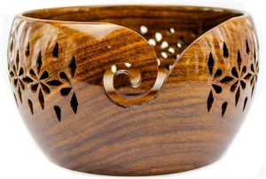a wooden yarn bowl carved with a floral print