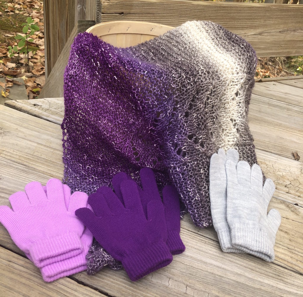 the mulberry shawl slides out of a basket, surrounded by three pairs of matching gloves