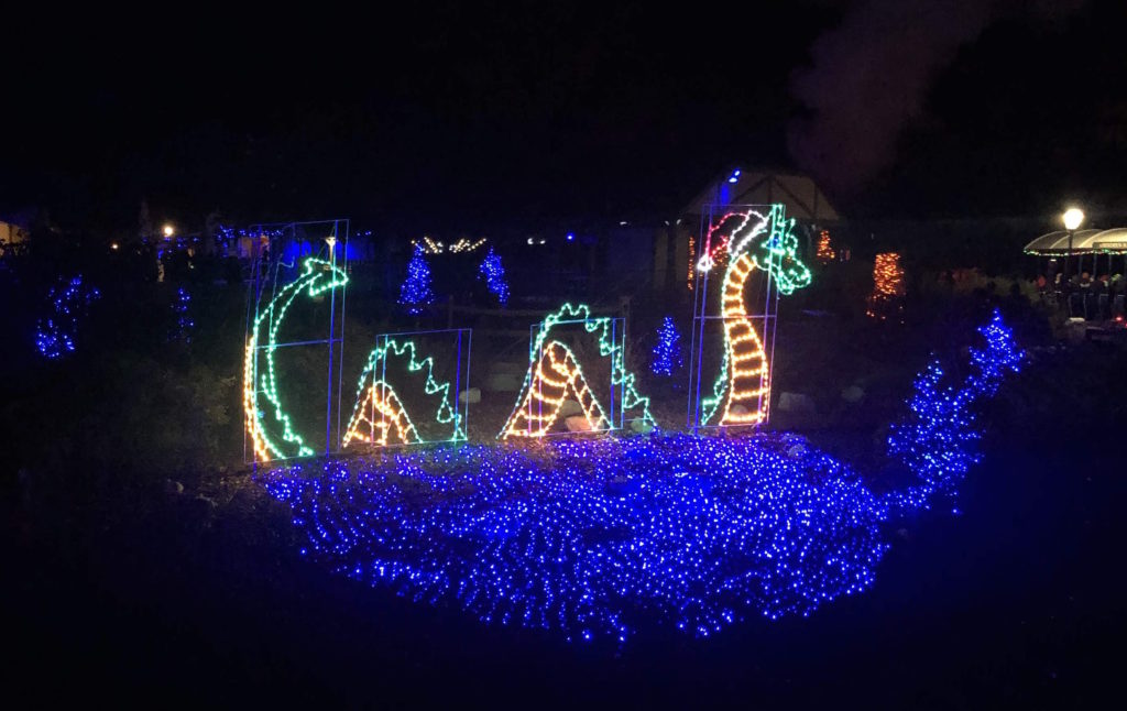 holiday lights in the shape of the Loch Ness Monster wearing a Santa hat decorate Christmas Town at Busch Gardens