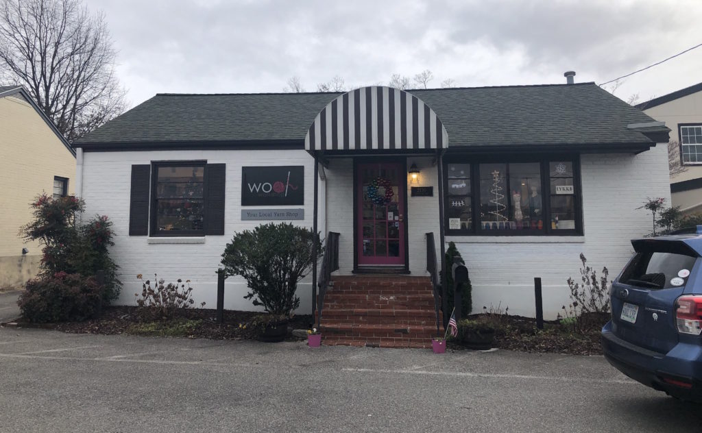 a small house-turned-shop with a sign that reads Wool Workshop