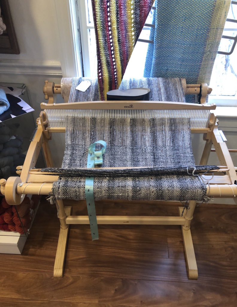 a weaving loom holds a project in wait for the weaver to return