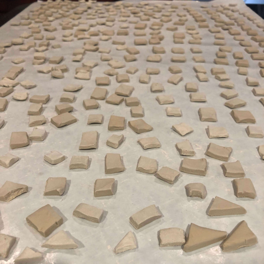 air-dry clay squares and triangles drying on wax paper