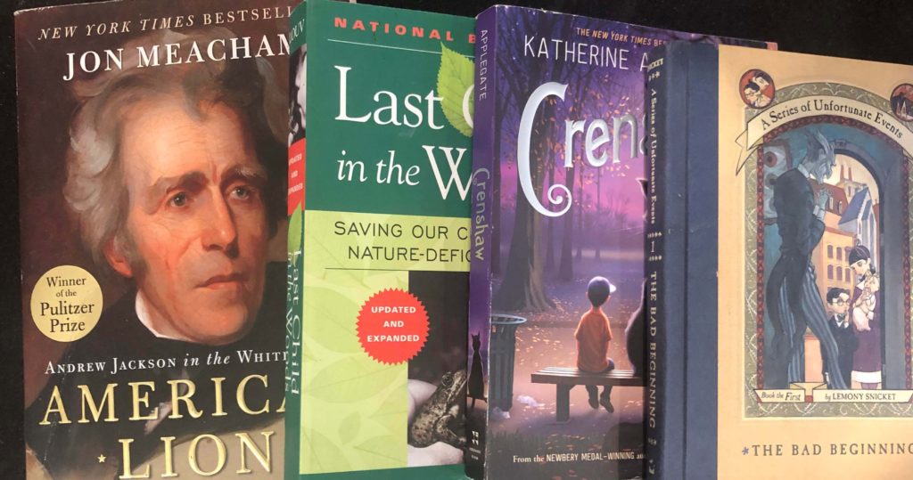 a pile of books: American Lion, Last Child in the Woods, The Bad Beginning, and Crenshaw