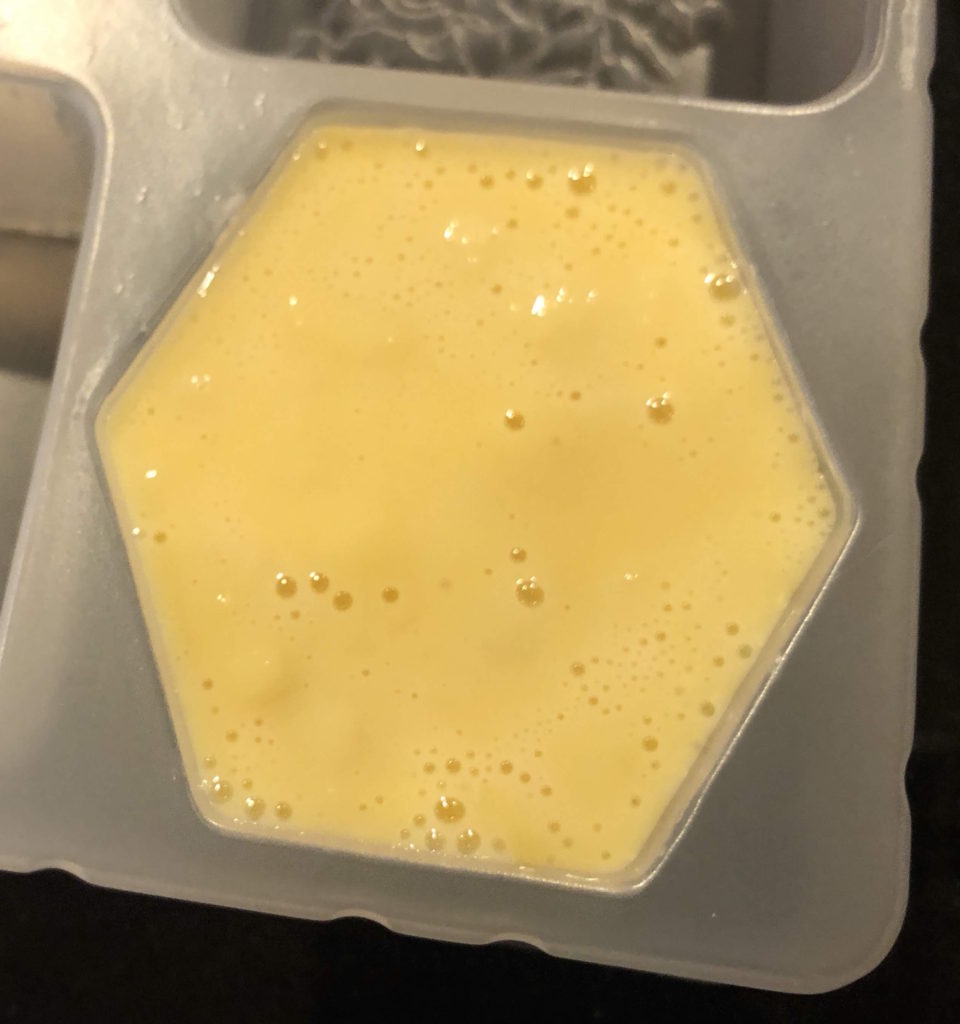 a close-up of yellow, honeycomb-shaped soap in a mold