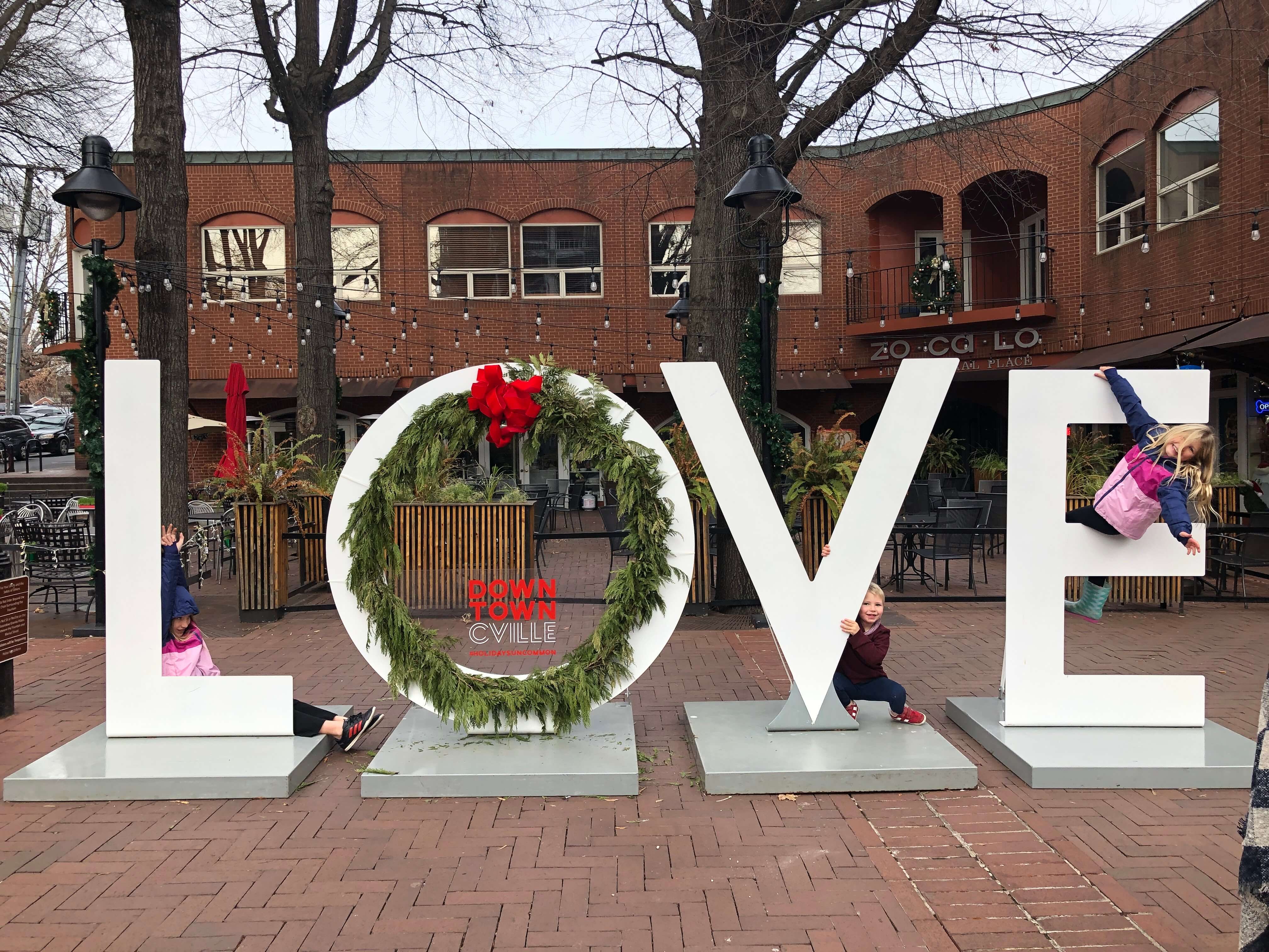 three children pose on the holiday-themed LOVEworks at Historic Downtown Charlottesville, Virginia