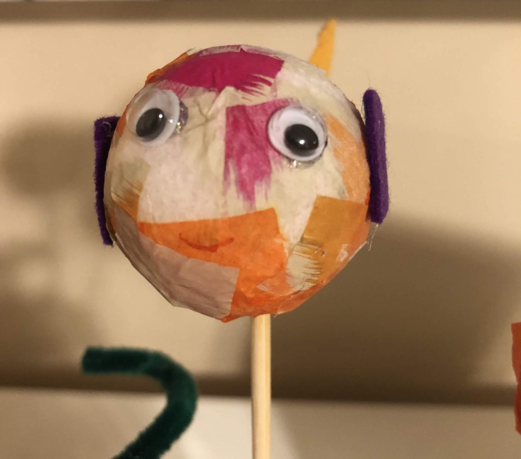 a foam ball fish: decoupaged styrofoam ball with googly eyes and felt fins on a dowel with a smile drawn on its face