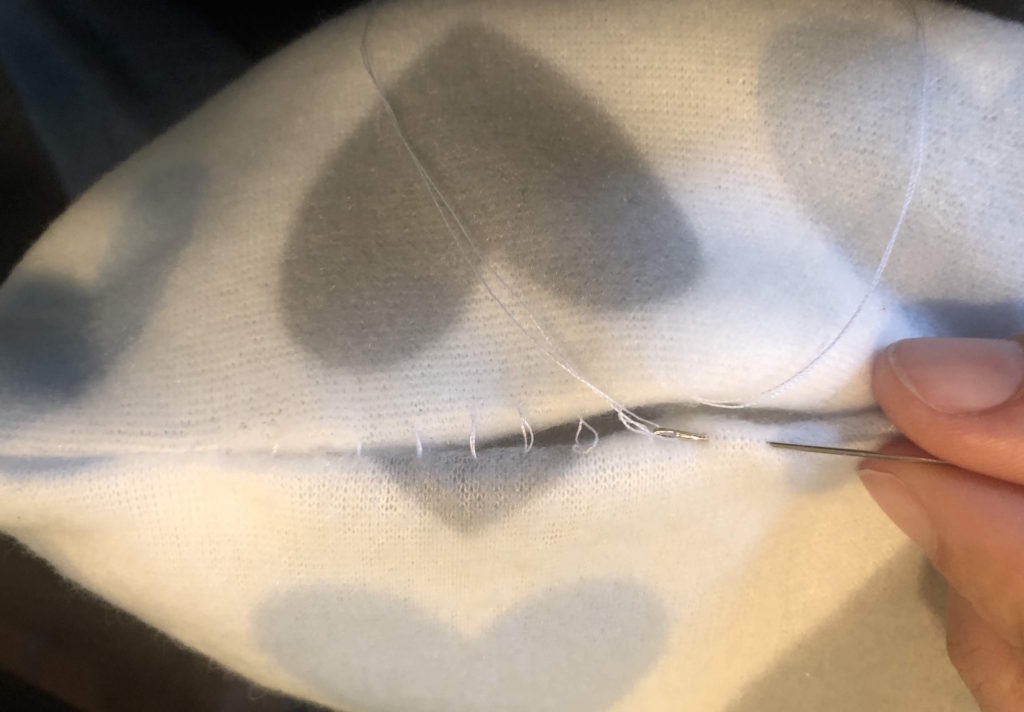 little hands sew the finishing seam on the pillow exterior