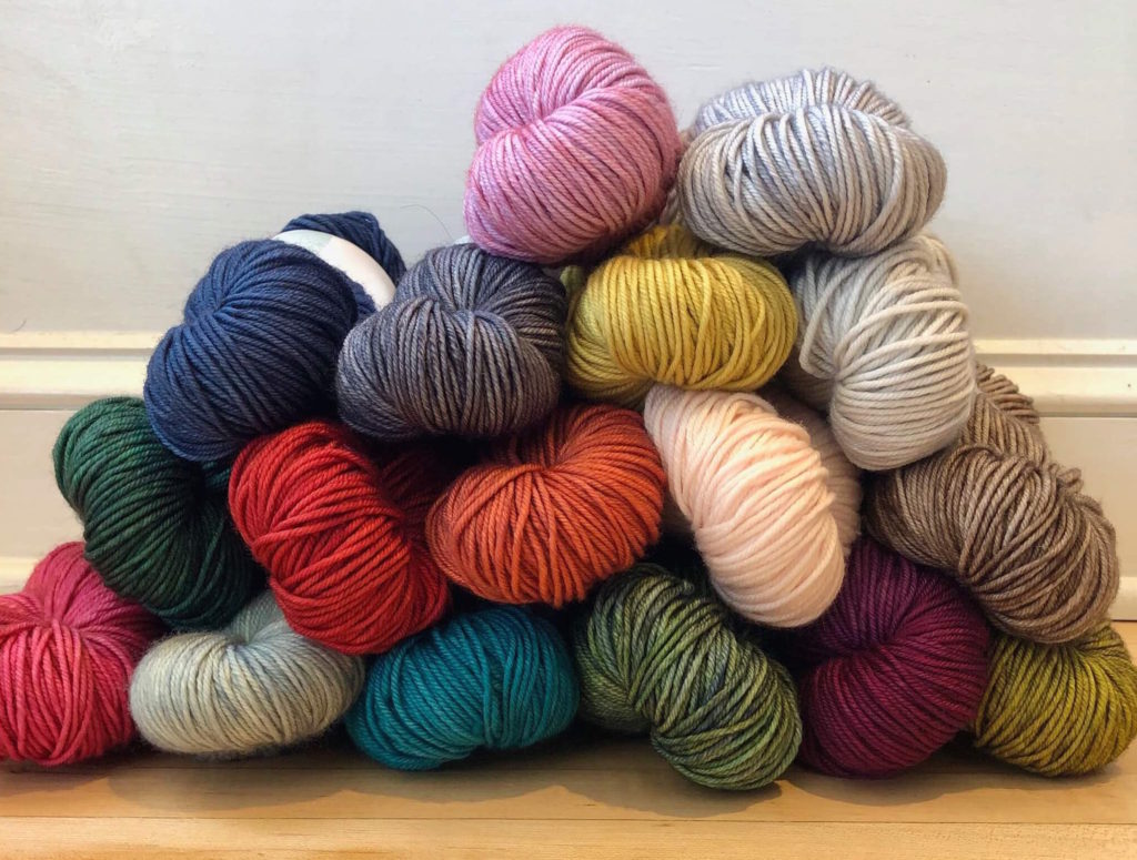 a pile of assorted skeins of yarn
