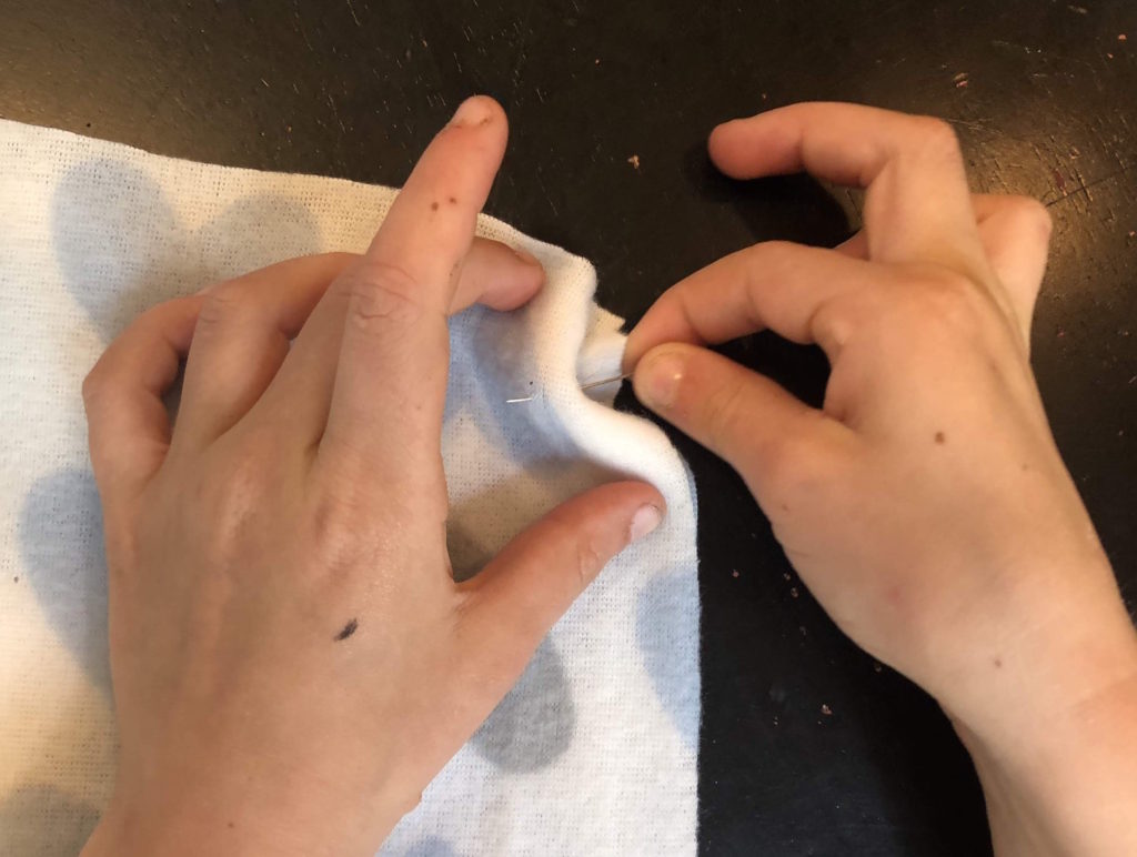 little hands pinning the wrong sides of two pieces of fabric together