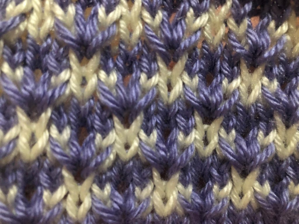 a closeup view of the thorn stitch, a knitting stitch worked in 2 colors, with the colors reversed