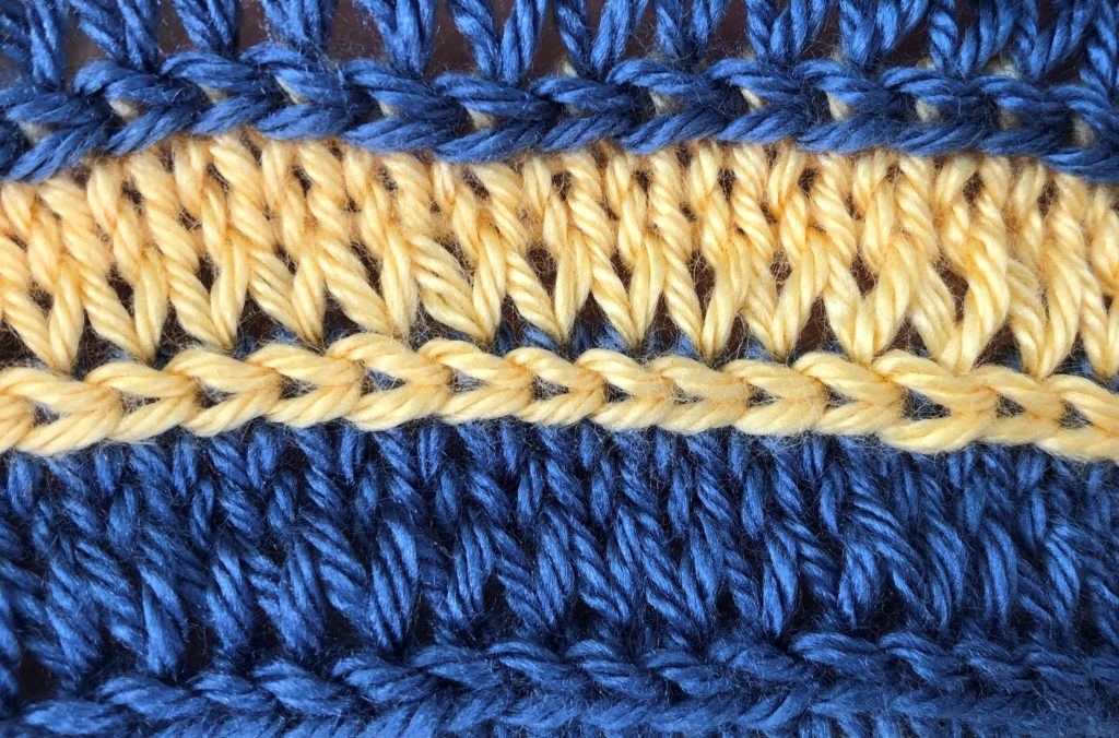 a close-up of the horizontal braid knitting stitch worked in alternating colors
