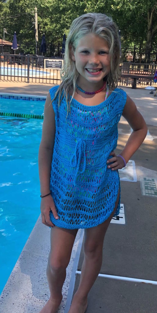 a young girl poses by the pool in a cotton swimsuit cover-up