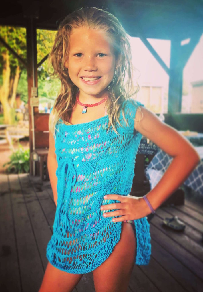 a young girl poses by a picnic table wearing a cotton swimsuit cover-up