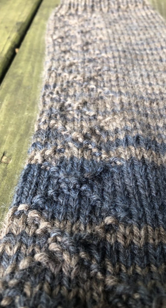 a close-up view of a sweater sleeve featuring the diamond brocade stitch