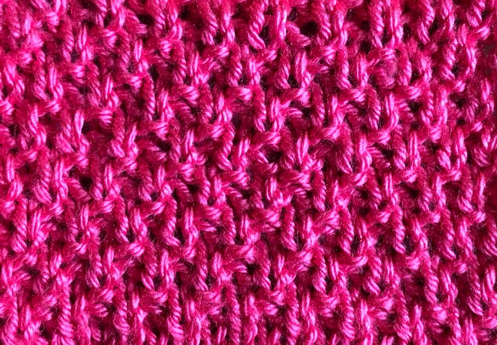 a close-up of knitted fabric in moss stitch