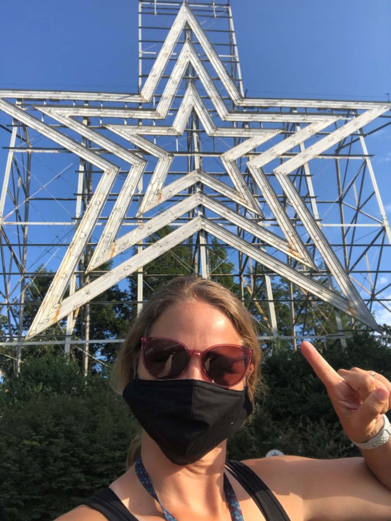 a woman points at the Roanoke Star from below its base