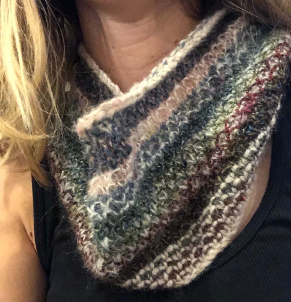 broken seed stitch cowl around someone's neck