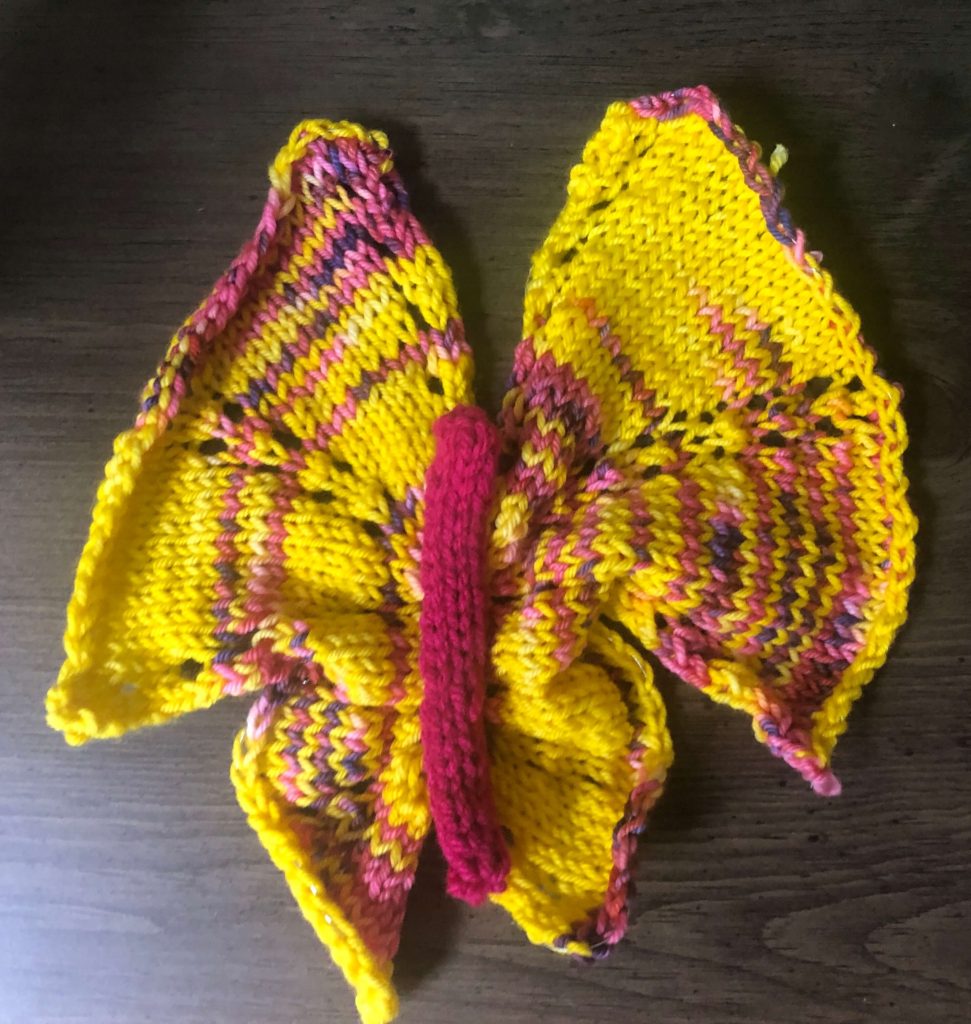 a knitted butterfly with widespread upper wings and bunched up lower wings