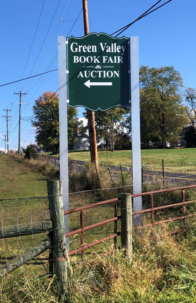 a sign reading "Green Valley Book Fair & Auction" points the way