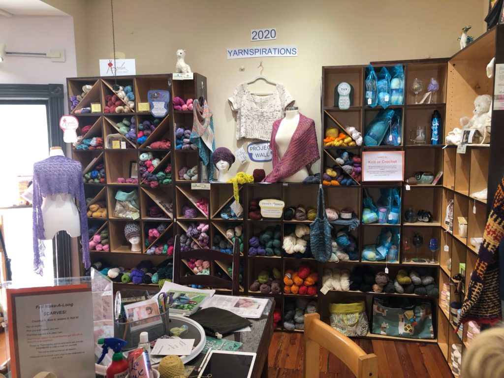 a wall of yarn marked Yarnspirations and full of skeins on shelves