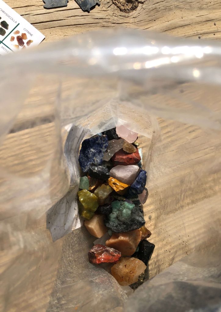 gems of all colors, sizes, and shapes at the bottom of a souvenir bag