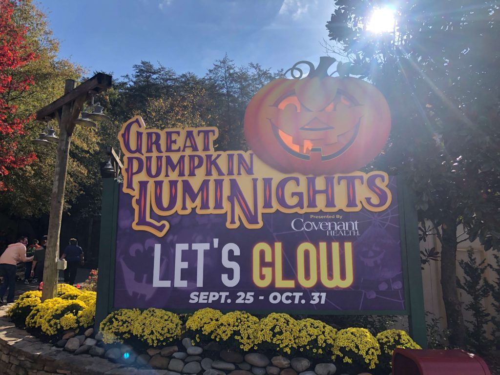 sun shines down on a giant sign reading:
GREAT PUMPKIN LUMINIGHTS
LET's GLOW
SEPT 25 - OCT 31