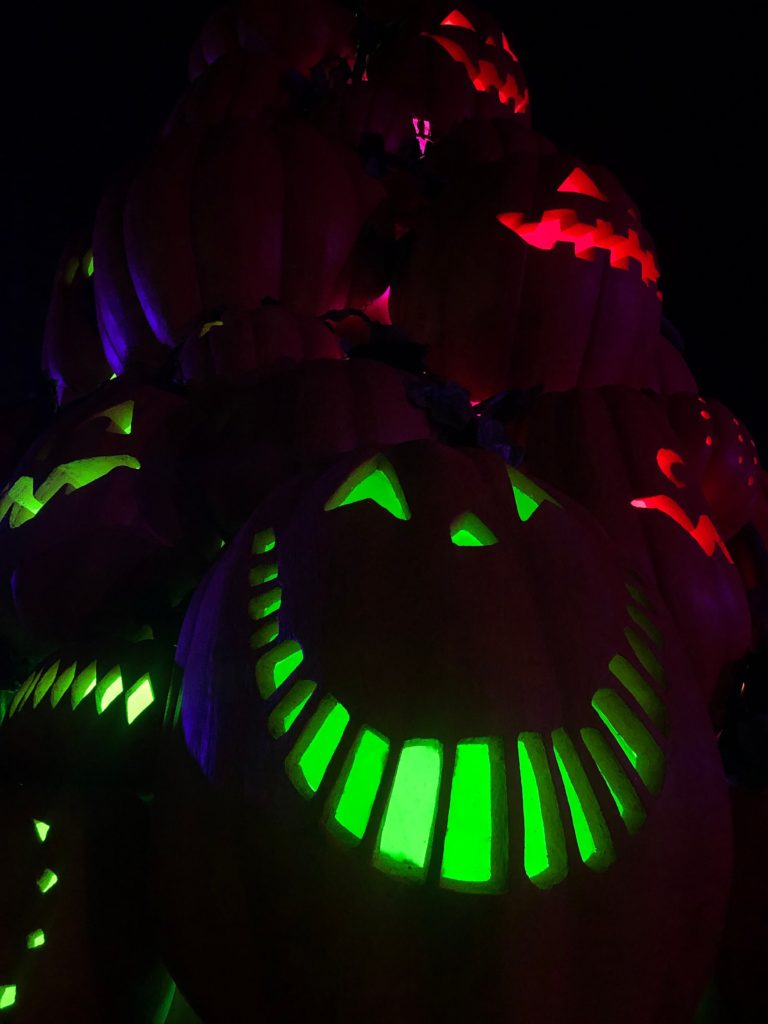 a close-up view of jack-o-lanterns smiling in the dark