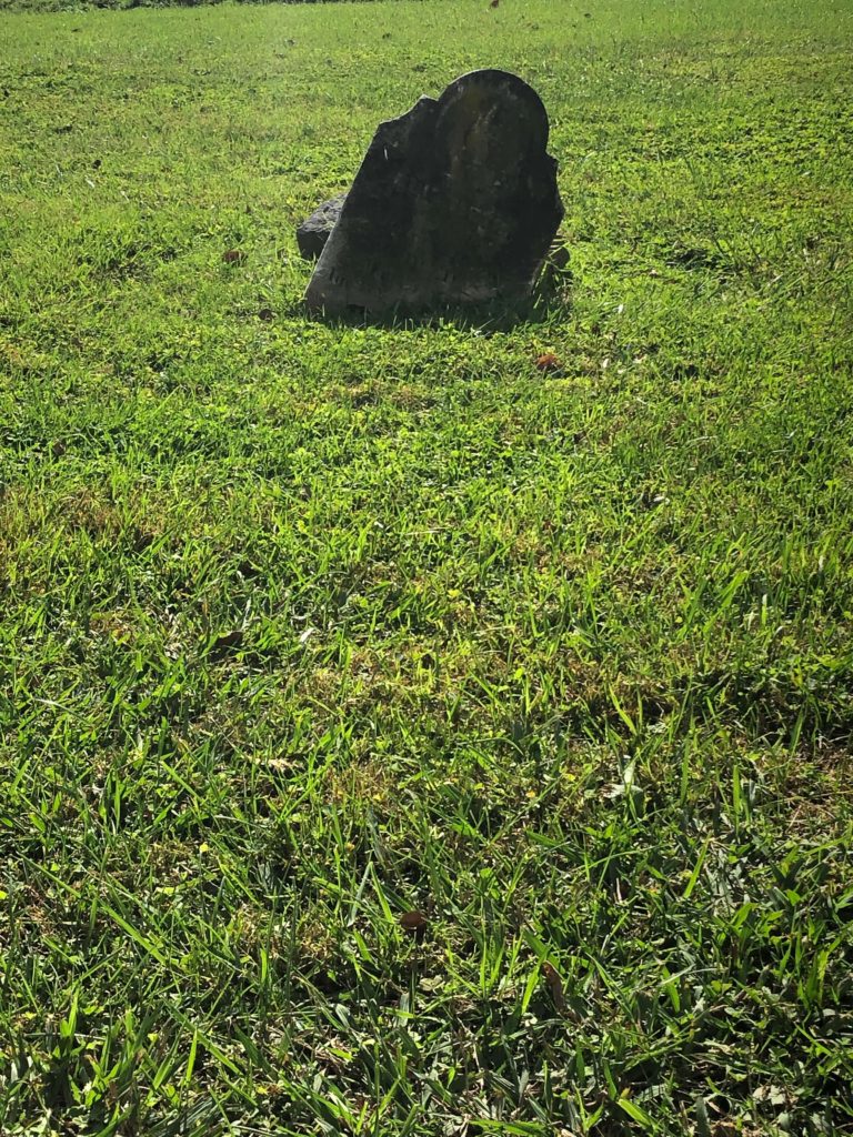 An aging headstone slumps to the side as if it is actually sinking at Sinking Spring Cemetery in Abingdon, Virginia.