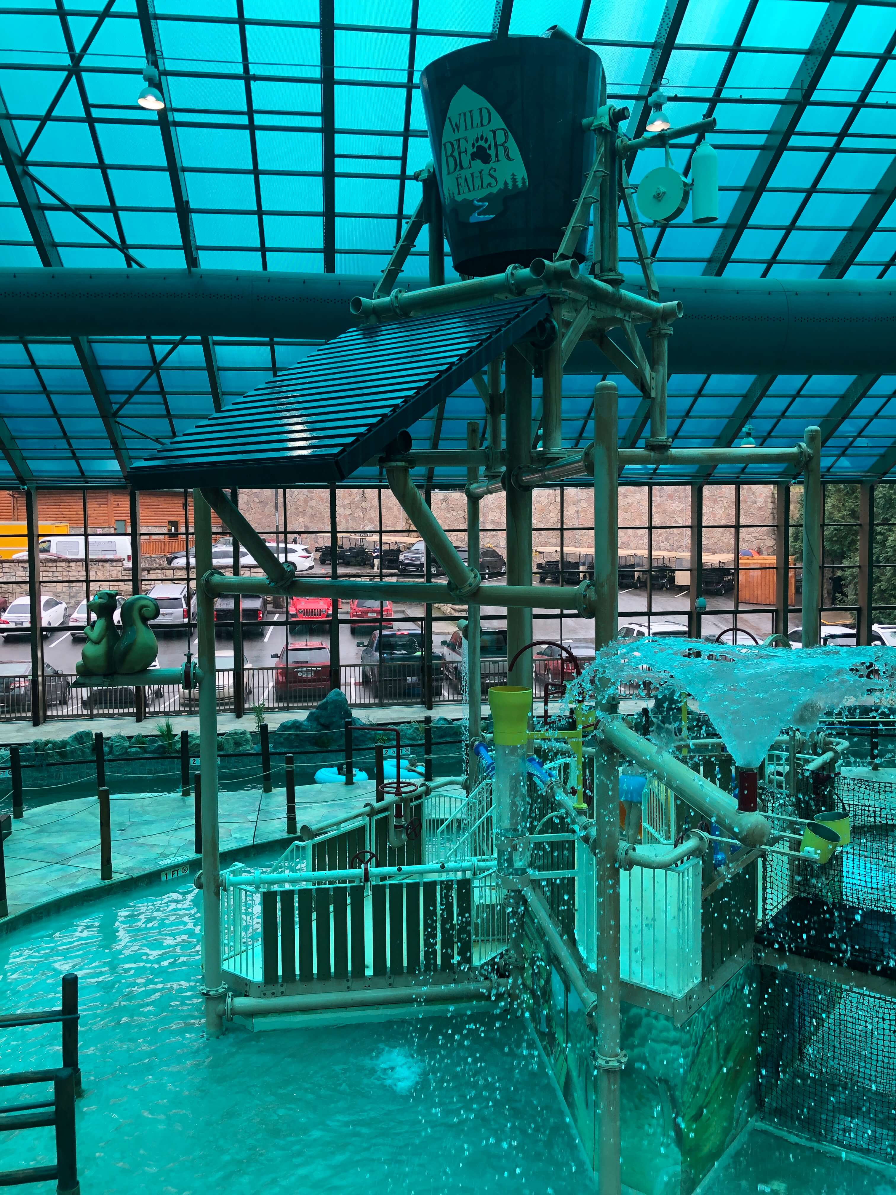 a giant bucket reading WILD BEAR FALLS sits atop a large water play structure