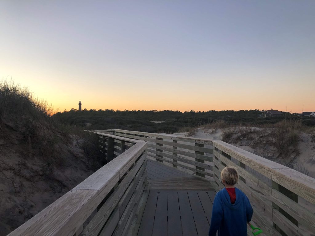 a young boy looks down the boardwalk of the Outer Banks