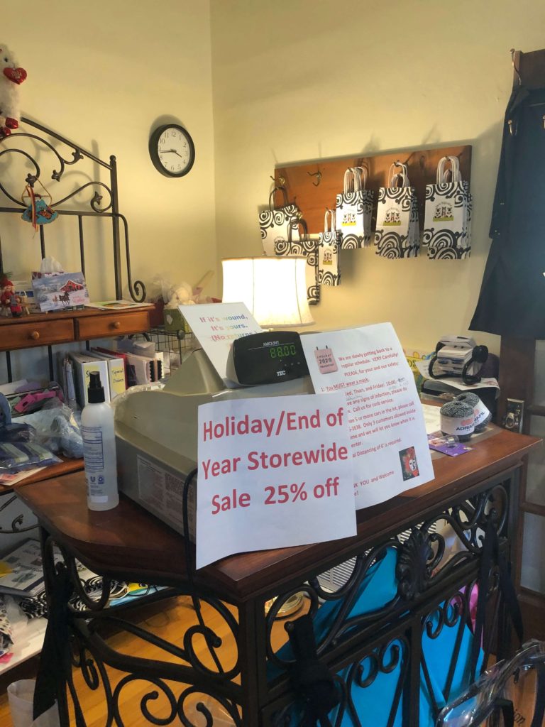 at the cash register, a large sign reads, "Holiday/End of Yar Storewide Sale 25% off"